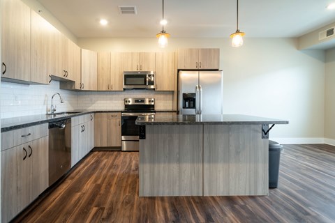 A modern kitchen with wooden cabinets and a central island.