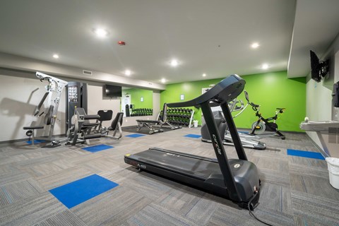 A gym with a treadmill in the foreground.