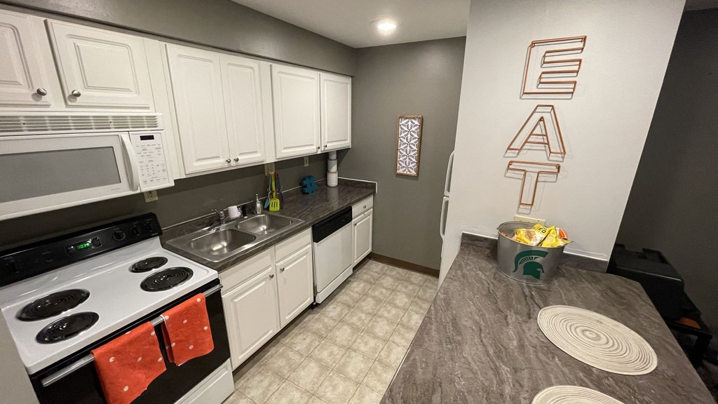 a kitchen with white cabinets and appliances and a counter top