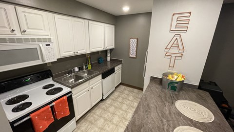 a kitchen with white cabinets and appliances and a counter top