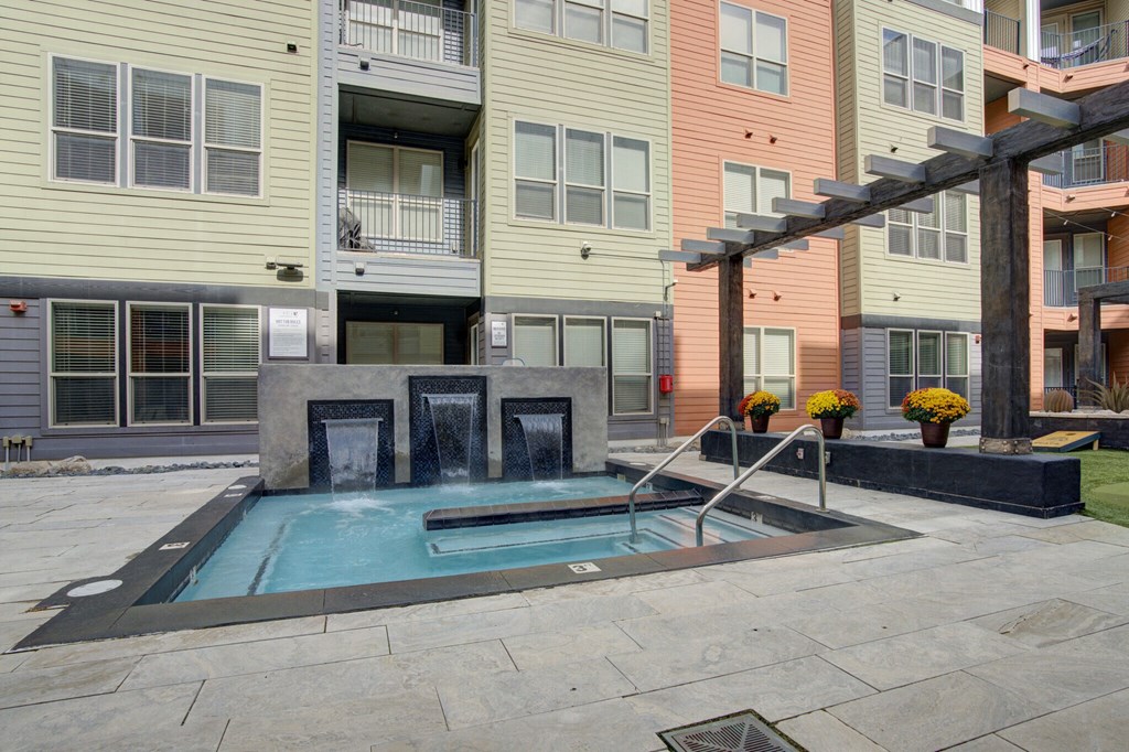 Resident courtyard with grills, putting green and hot tub | Vista at the Heights Apartments in Lansing MI