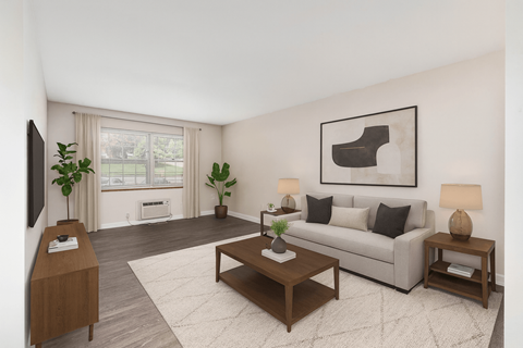 A living room with a grey couch, a coffee table, and a painting on the wall.