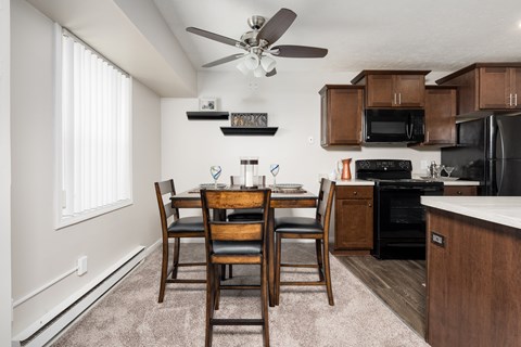 A kitchen with a dining table and chairs.