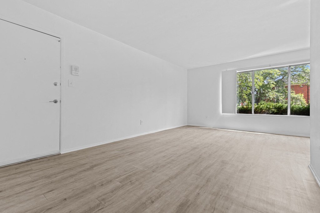 a bedroom with hardwood floors and white walls