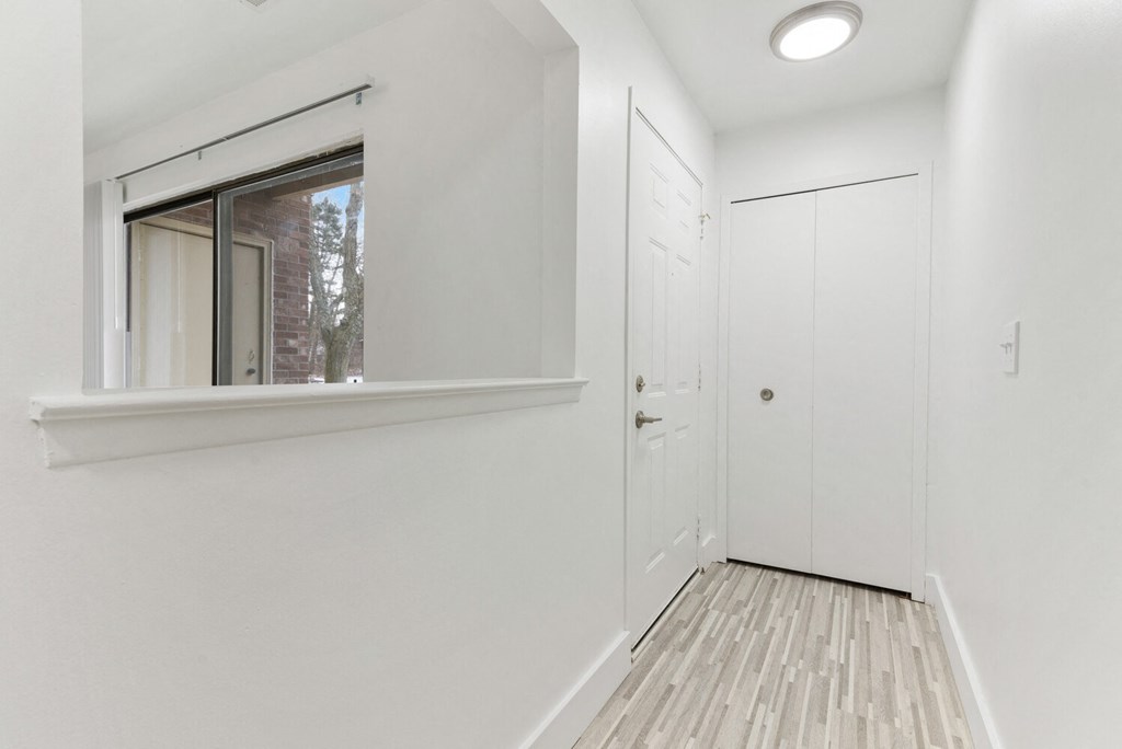 a bedroom with white walls and a window and a door