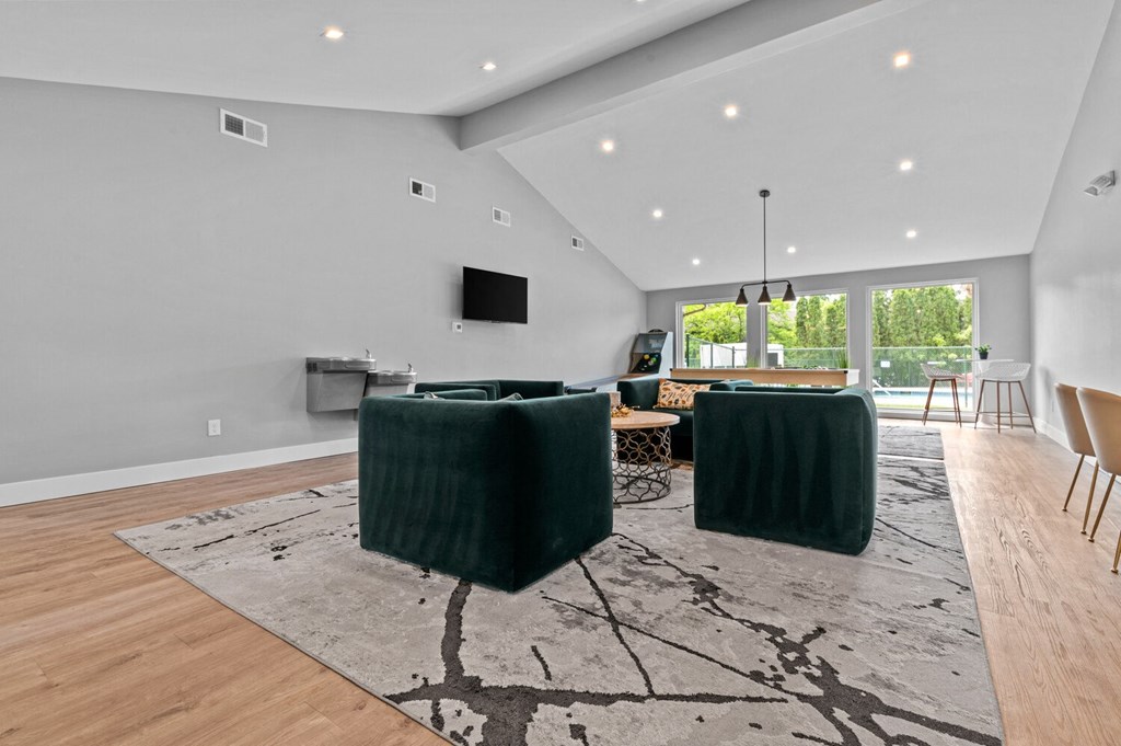 a living room with two green couches and a rug