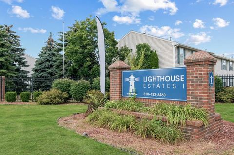 a sign that says lighthouse estates with a house in the background