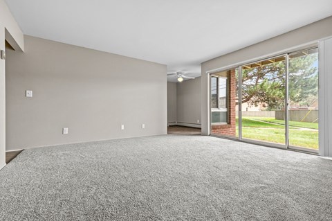 a spacious living room with a sliding glass door to the backyard