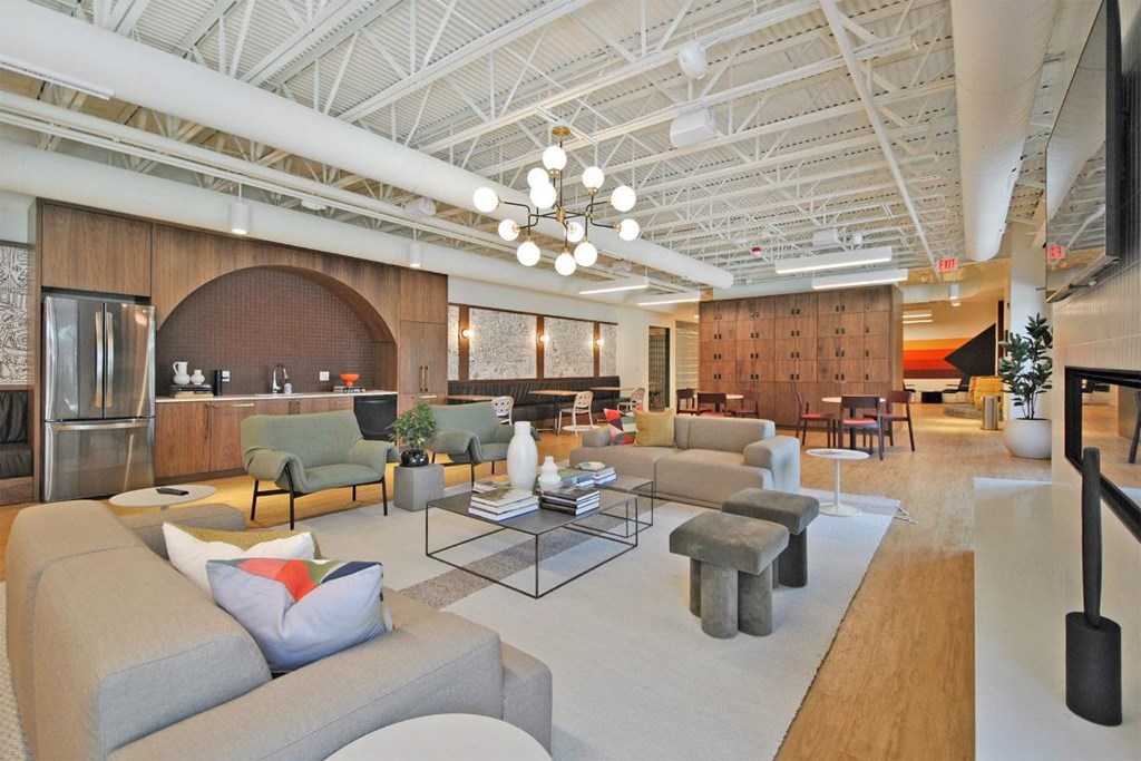 A modern living room with a grey sofa and a glass coffee table.