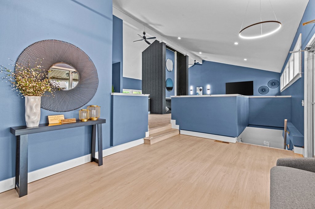 a living room with blue walls and a wooden floor