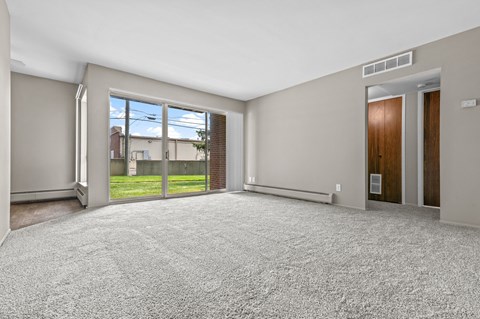 a living room with a large window and a door leading to a yard