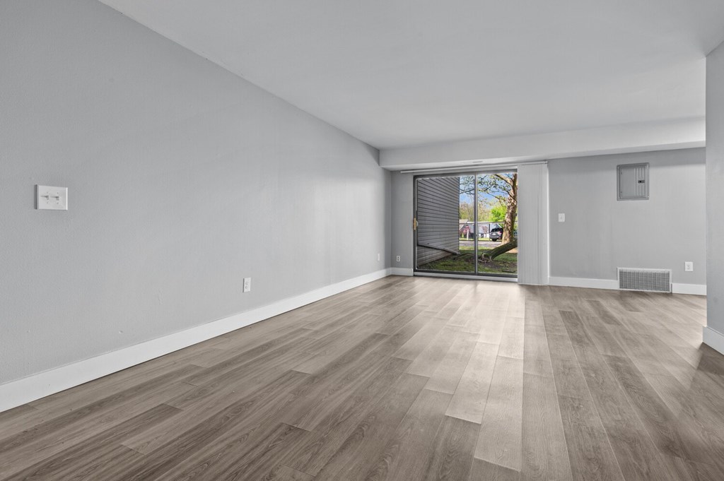 A room with light wood flooring and white walls.