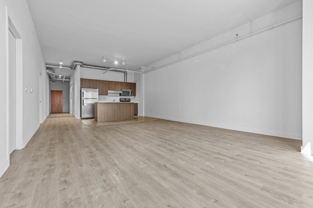 an empty living room with white walls and hardwood floors