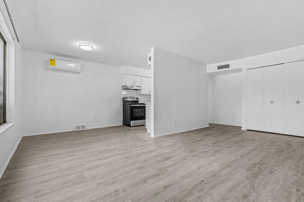 a living room with white walls and hardwood floors