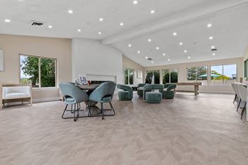 the gathering room with chairs and tables and a fireplace