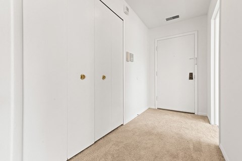 a bedroom with white walls and white closet doors
