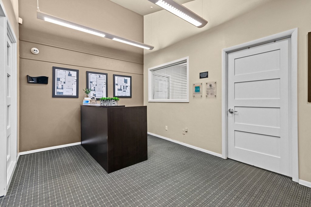 an office lobby with a desk and a door