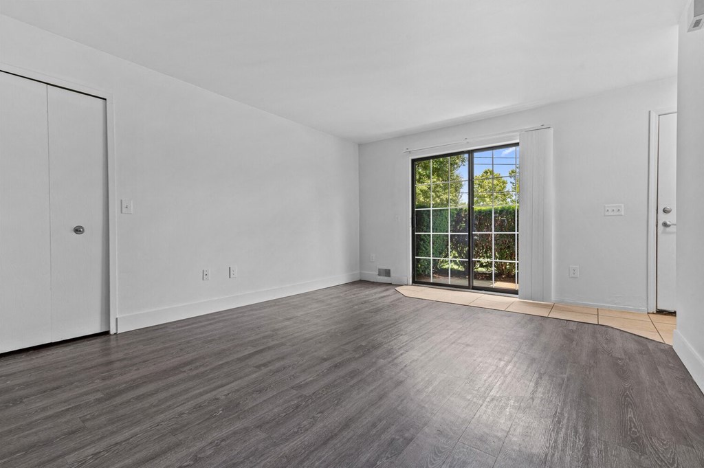 a bedroom with hardwood floors and white walls