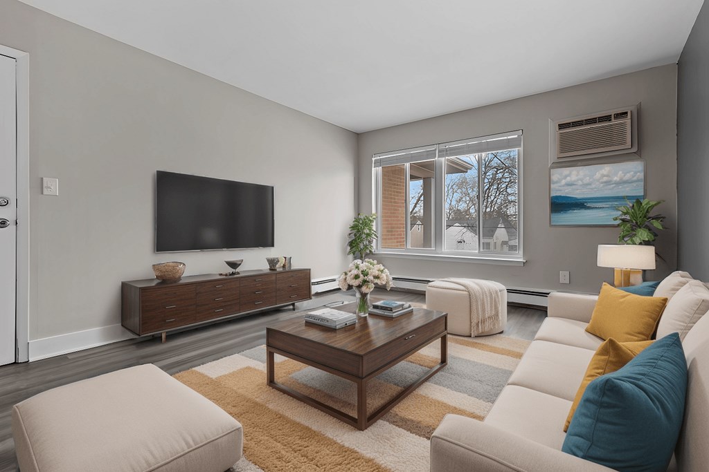 A living room with a brown coffee table and a white couch.