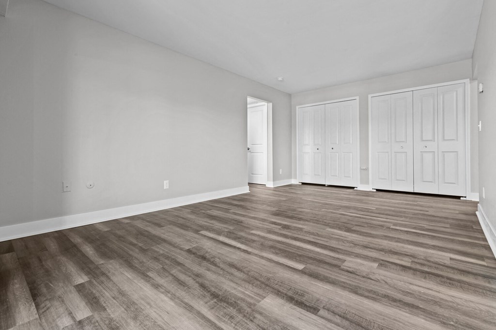 the living room of a new home with white walls and wood flooring at Sunnymede Apartments - Troy, MI, Troy, 48084