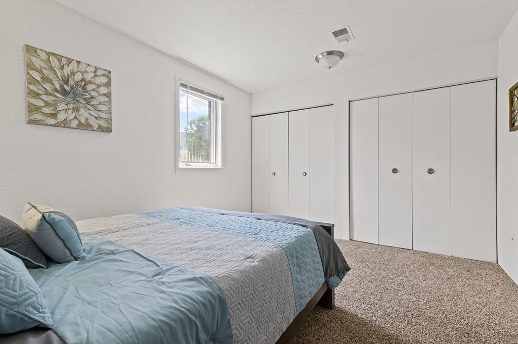 a bedroom with a large bed and white closets