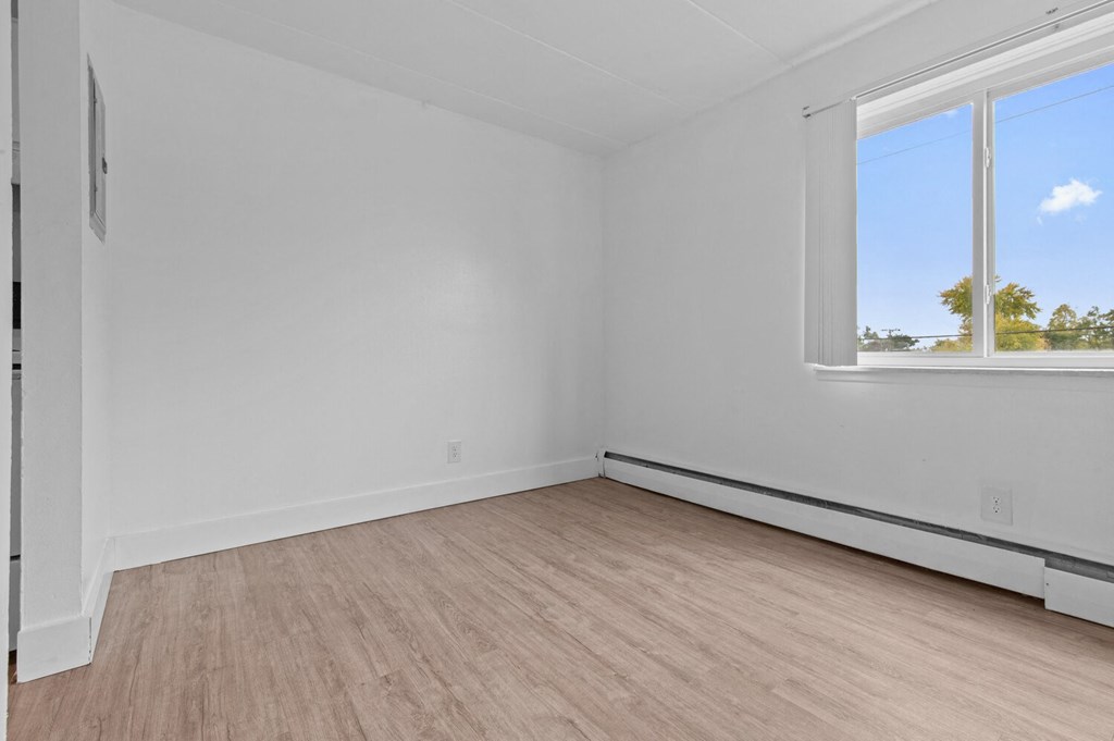 an empty room with white walls and a window