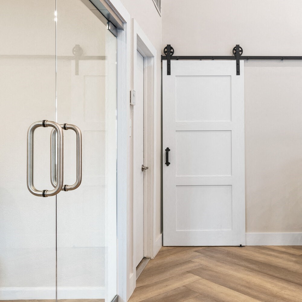 a sliding glass door in a room with white walls and wood floors