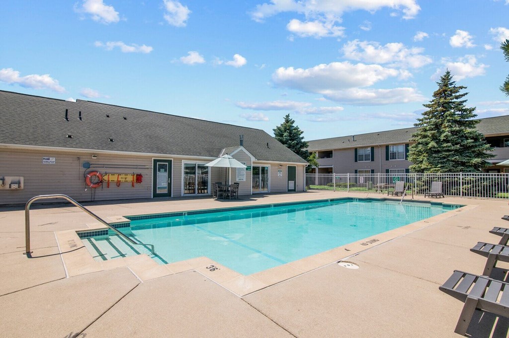 a swimming pool with a gray building in the background