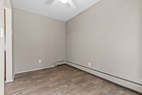 a bedroom with grey walls and a wooden floor
