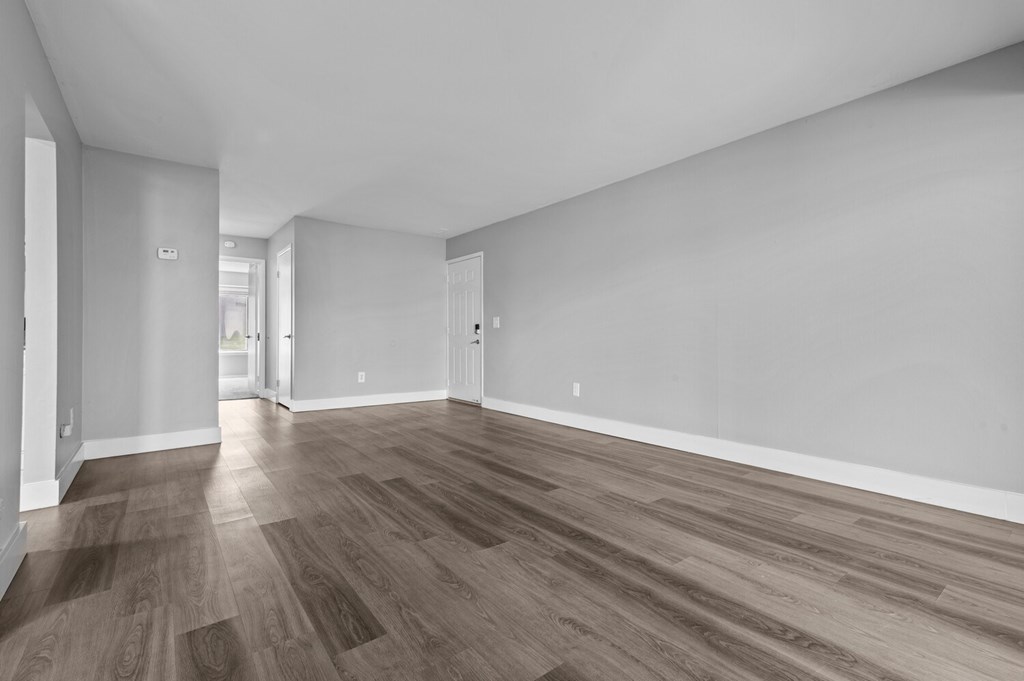 A room with wooden flooring and white walls.
