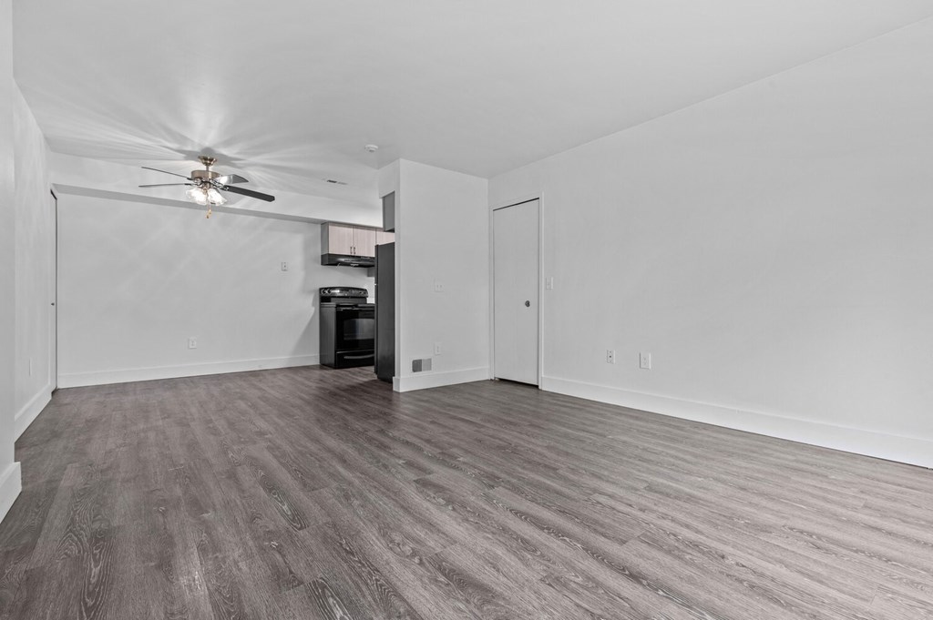a bedroom with hardwood floors and white walls