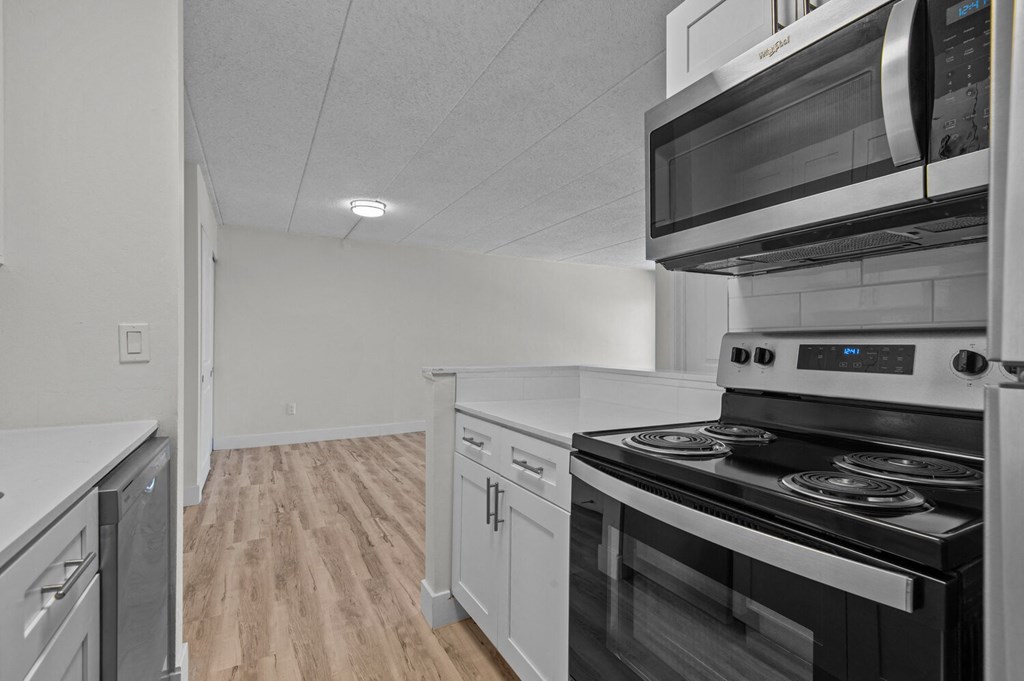 an empty kitchen with a stove and a microwave