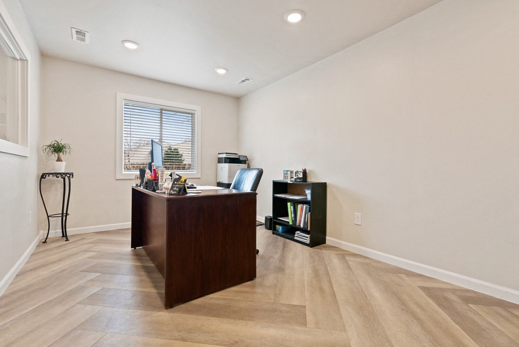 an office with a wooden desk and a window