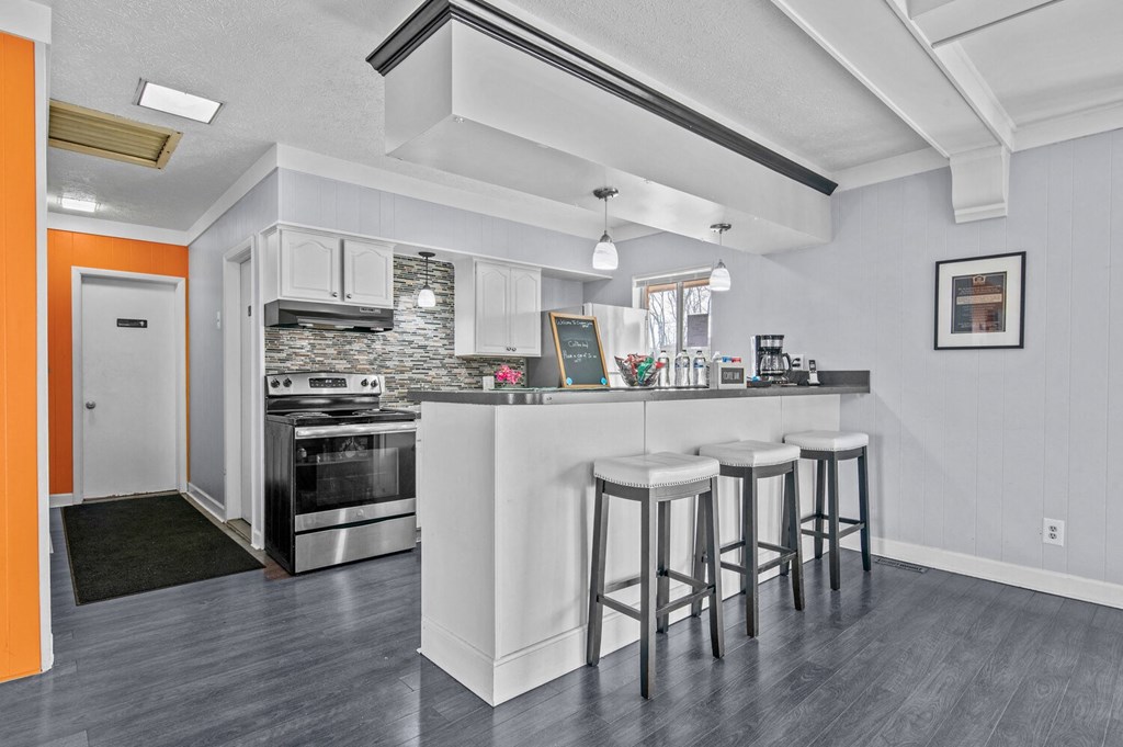 a kitchen with a bar with three stools