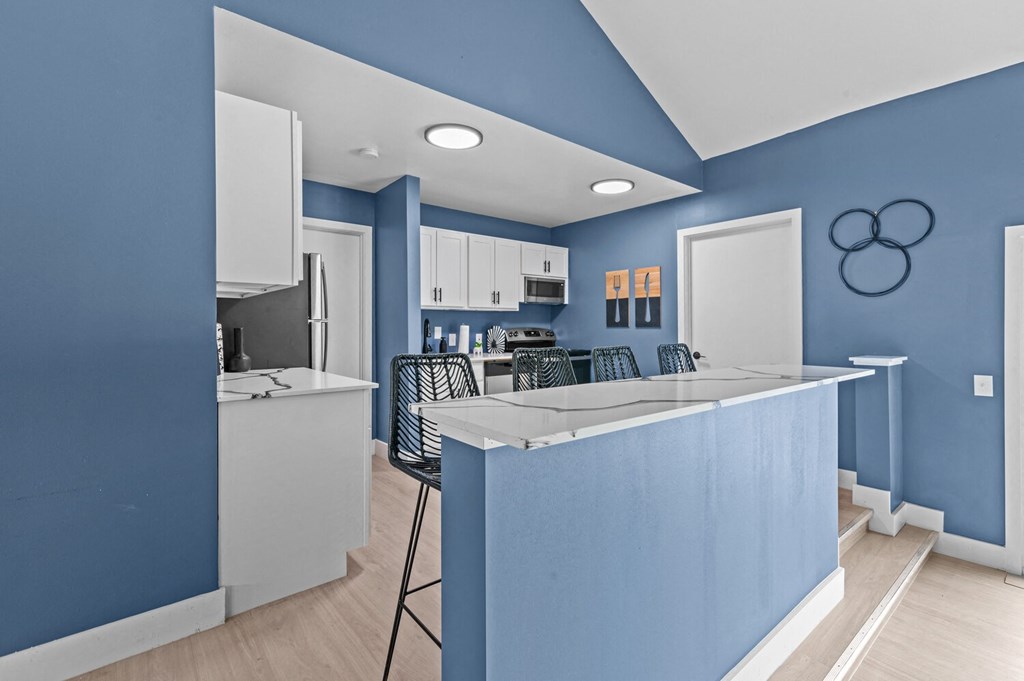 a kitchen with blue walls and a white counter top