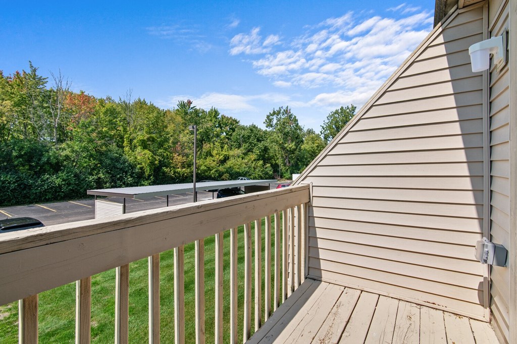 the deck of a home with a view of a yard and trees