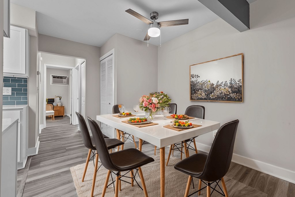 A dining room with a table set for four.