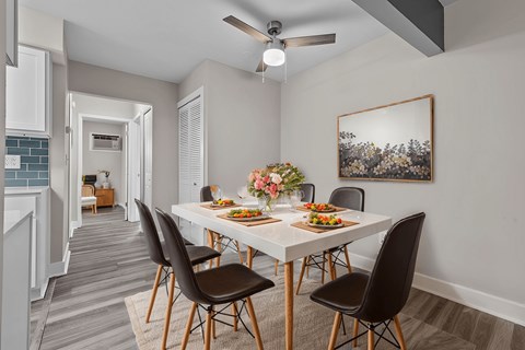 A dining room with a table set for four.