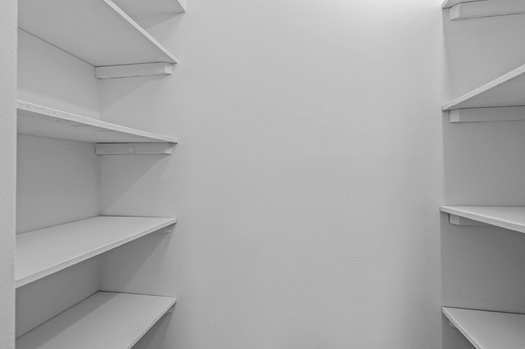 white shelves in a white closet in a room