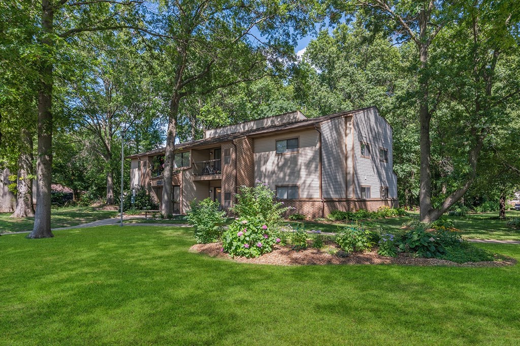 a house in the middle of a yard with trees
