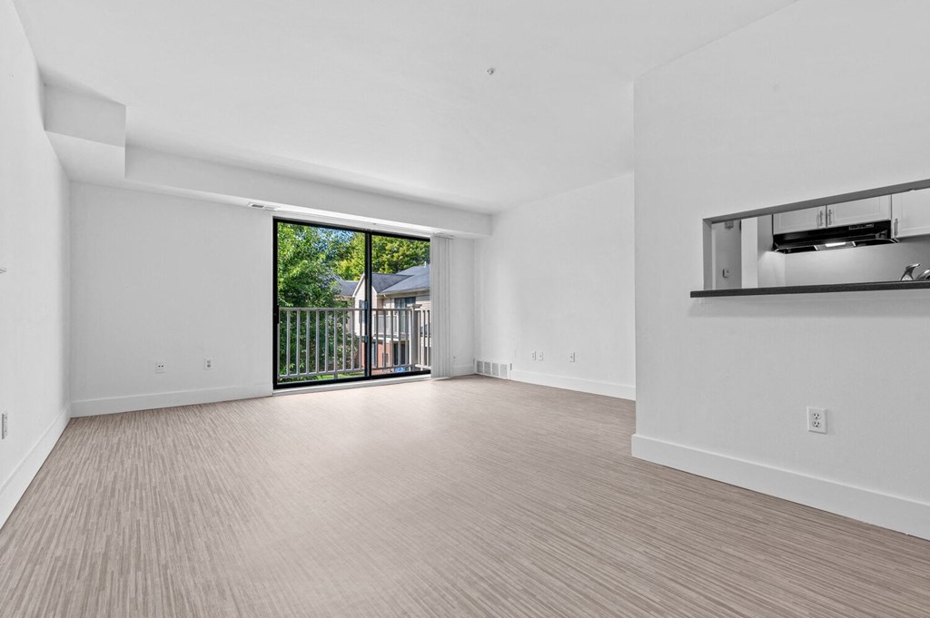 a living room with a sliding glass door and a balcony