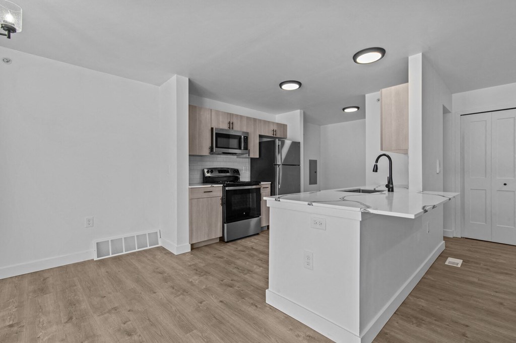 an empty kitchen with a large counter top and a sink