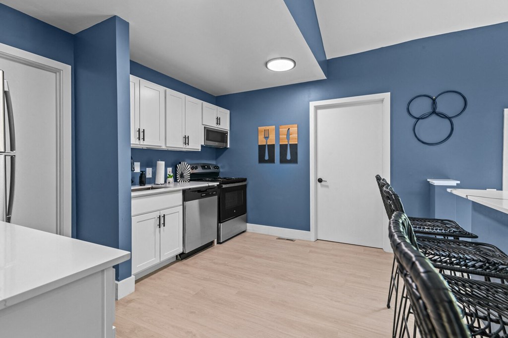a blue and white kitchen and dining room with a table and chairs