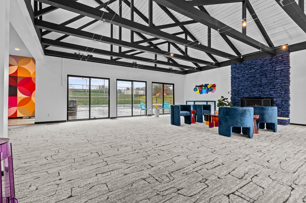 a large living room with blue chairs and a fireplace