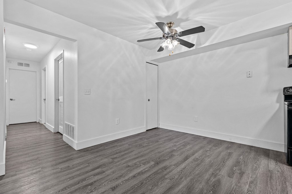 a bedroom with white walls and a ceiling fan