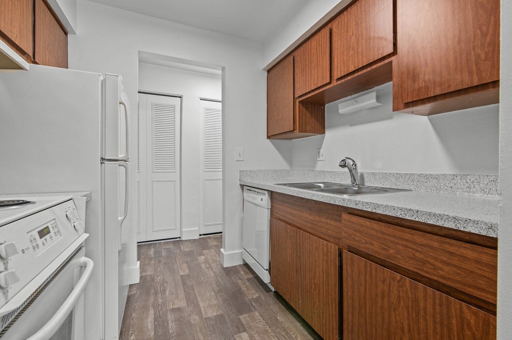 a kitchen with white appliances and wood cabinets