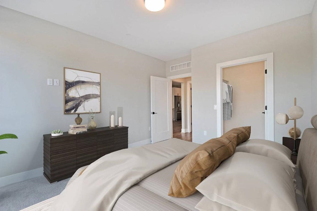 A bedroom with a large bed and a wooden dresser.