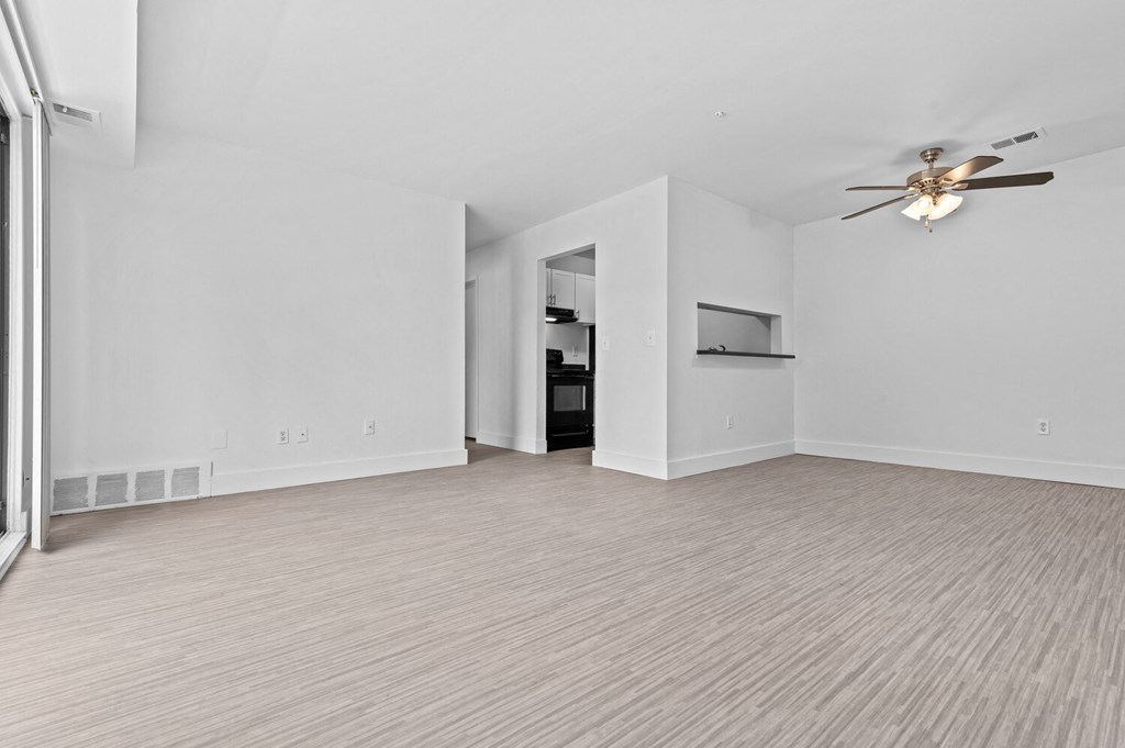 a bedroom with white walls and a ceiling fan
