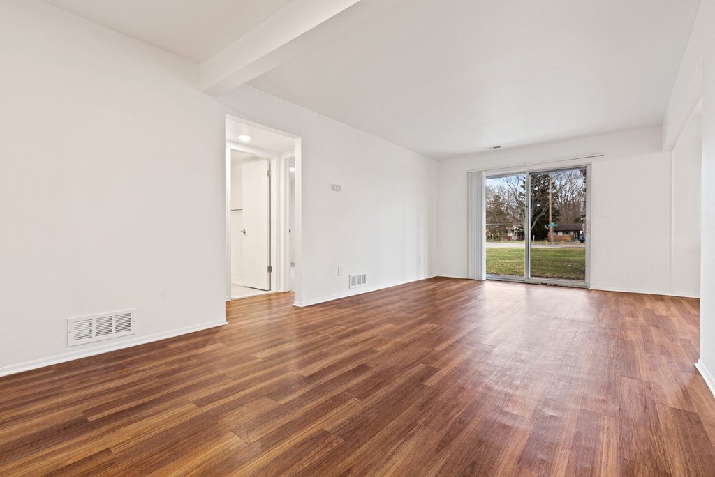 a living room with a hard wood floor and a sliding glass door