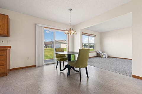 a dining room with a table and chairs and a window